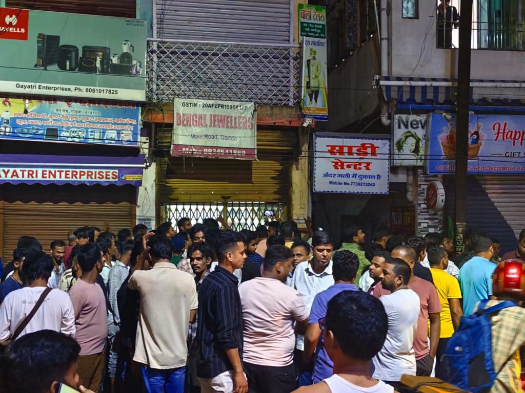 गोड्डा के बंगाल ज्वेलर्स के बाहर दिनदहाड़े लूटकांड के बाद जुटी भीड़ और पुलिस जांच करती हुई।