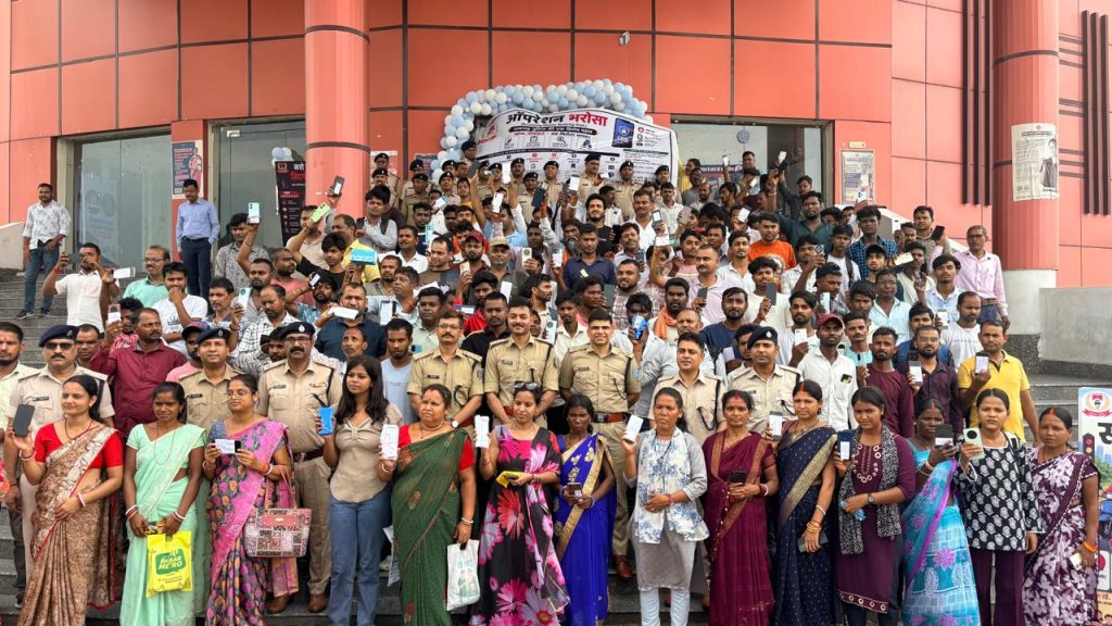रामगढ़ पुलिस का ऑपरेशन भरोसा सफल, 125 गुम मोबाइल मालिकों को लौटाए रामगढ़ न्यू टाउन हॉल में पुलिस अधीक्षक द्वारा नागरिकों को बरामद मोबाइल फोन सौंपते हुए, मंच पर "ऑपरेशन भरोसा" का बैनर, पुलिस अधिकारी, खुश नागरिक, प्रेस कैमरे, भारतीय पुलिस समारोह, यथार्थवादी समाचार शैली, 16:9 अनुपात, ऊपर "दैनिक स्टेट" लोगो।